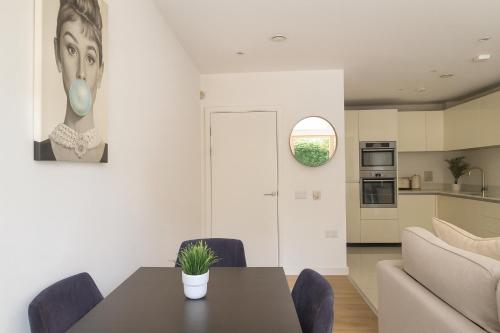 a kitchen and living room with a table and a couch at Elegant 2 Bed Flat with Balcony in Finchley in Hendon