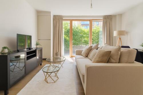 a living room with a white couch and a television at Elegant 2 Bed Flat with Balcony in Finchley in Hendon