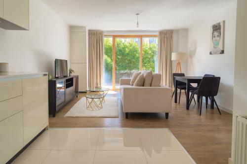 a living room with a couch and a table at Elegant 2 Bed Flat with Balcony in Finchley in Hendon