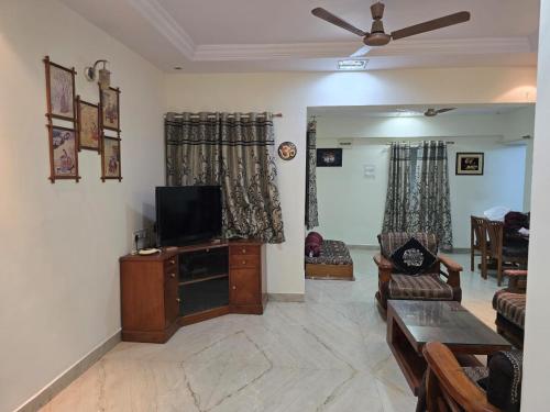 een woonkamer met een bank en een tv bij 3BHK Flat Rudrashakti Enclave Nagpur in Nagpur