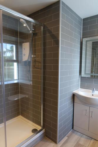 a bathroom with a shower and a sink at Pink House Skye in Portree