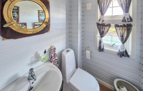 a bathroom with a white toilet and a mirror at 4 Bedroom Gorgeous Home In Steinsland in Steinsland