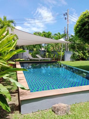 a swimming pool with a white umbrella over it at Tranquility in Bangrak Beach