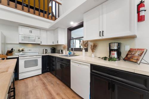a kitchen with white cabinets and white appliances at Spacious Waterfront Mansion wHot tubPoolTable in East Stroudsburg