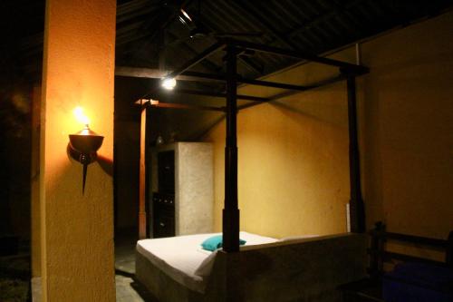 a bedroom with a canopy bed with a light on it at Village Verandah by Oshi in Dambulla