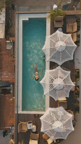 a person in the water in a pool with umbrellas at Saint Nicolas Hotel in Himare