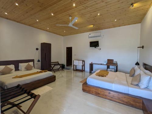 a bedroom with two beds and a ceiling fan at Eco Hotel Black & White - Anuradhapura in Mihintale