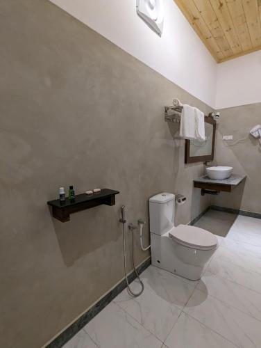 a bathroom with a toilet and a sink at Eco Hotel Black & White - Anuradhapura in Mihintale
