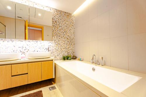 アブダビにあるSophisticated 2BR in Mayan with Golf View 905の浴槽、洗面台、鏡のあるバスルーム