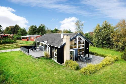 a house with a black roof on a green field at OH253-Hadsund-Halvrebene-37 in Hadsund
