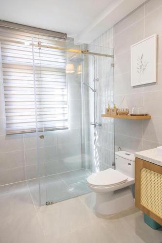 a bathroom with a glass shower and a toilet at JOYY Villa 4PN-3WC-5 giường NovaWorld Phan Thiết in Bình Tú