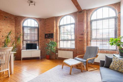 a living room with brick walls and a couch and a tv at 5 mins walk from centre, spacious city apt, open-plan in Nottingham
