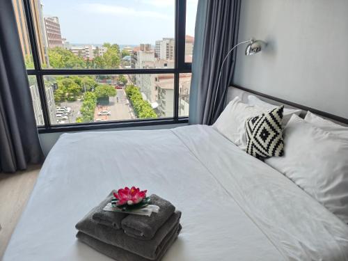a bedroom with a white bed with a large window at The base Central Pattaya 2 bedrooms in Pattaya Central