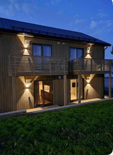 a house with a large deck on the side of it at Thunehuset in Andøya
