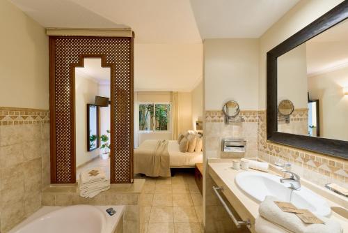 a bathroom with a tub and a sink and a bed at SANTA CRUZ SUITE Jardín con vistas Mijas Costa in Málaga