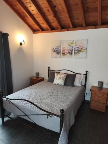 a bedroom with a bed and a wooden ceiling at Casa das Hortênsias in Horta