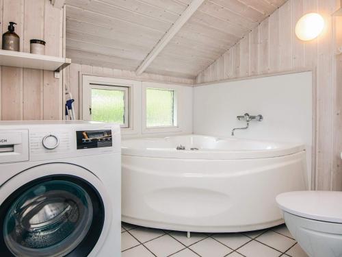 eine Waschküche mit Waschmaschine und Waschbecken in der Unterkunft Secluded Haven in Hvidbjerg - By Traum Ferienwohnungen in Egeskov