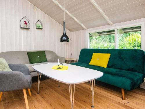 a living room with a green couch and a white table at Secluded Haven in Hvidbjerg - By Traum Ferienwohnungen in Egeskov