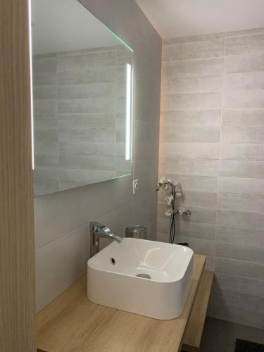 a bathroom with a white sink and a mirror at Maison Jazharra -SPA - 6 - 8 pers - Proche Golf in Frehel