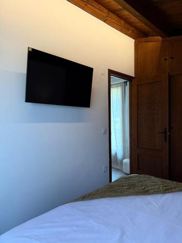 a bedroom with a bed with a flat screen tv on the wall at Casa Petra in Morillo de Monclús