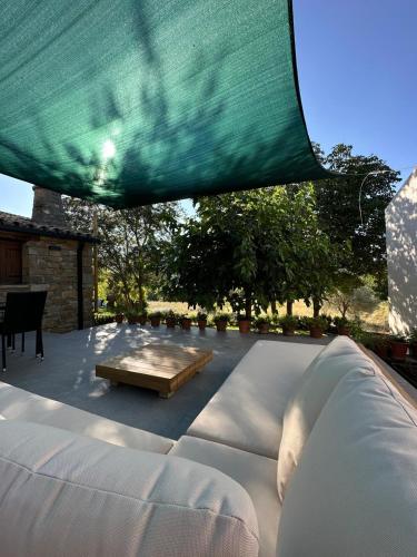 a white couch and a table under a green canopy at Casa Petra in Morillo de Monclús