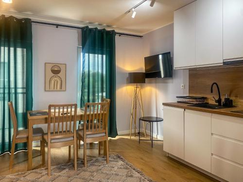 a kitchen and dining room with a table and chairs at Apartament Bałtycki in Jastrzębia Góra