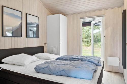 a bedroom with a bed with two pillows and a window at OH165-Hadsund-Bakkerne-2 in Hadsund