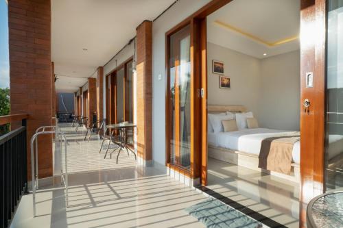 a bedroom with a bed on a balcony at Narmada House Seminyak in Seminyak