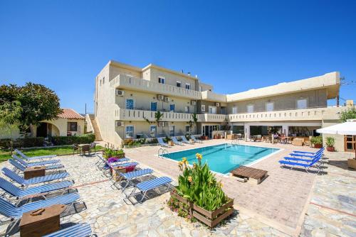 a large hotel with a swimming pool and lounge chairs at Despina Apts by Estia in Gouves