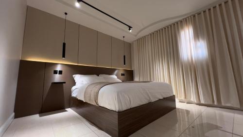 a bedroom with a large bed and a large window at Hotel studio with modern design, self check-in and a special location in Unayzah