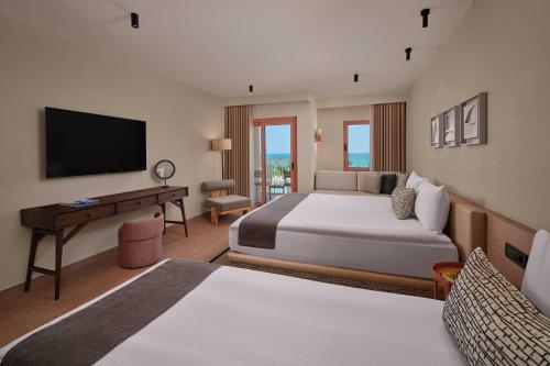 a hotel room with two beds and a television at Paloma Grida in Belek