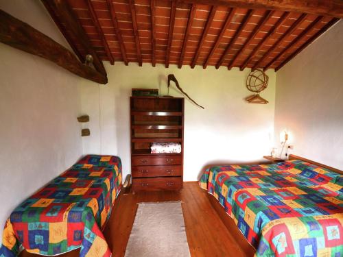 a bedroom with two twin beds and a dresser at Cottage in Pescia with Pool & Garden in San Quirico