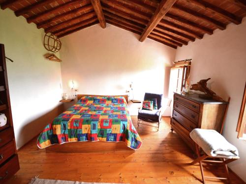 a bedroom with a bed and a chair and a dresser at Cottage in Pescia with Pool & Garden in San Quirico