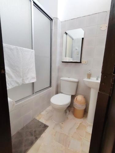 a bathroom with a toilet and a sink and a mirror at Del Sol Suites - Guayaquil in Guayaquil