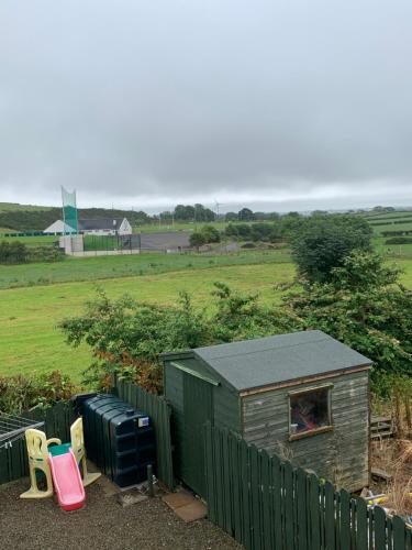 a small shed with a fence and a field at Cappagmore in Portstewart