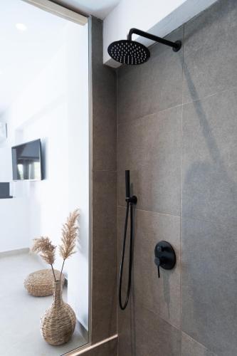 a bathroom with a shower with a glass door at Vinedo Luxury Escape Apartments in Kithnos