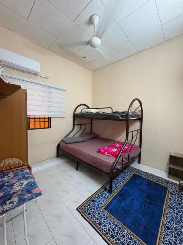 a room with two bunk beds and a rug at Nadis Guesthouse in Ipoh