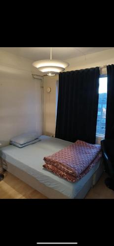a large bed in a room with a window at Joy Vulcan Center apartment in Oslo