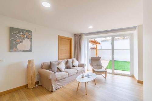 ein Wohnzimmer mit Sofa und Tisch in der Unterkunft Amplia casa rural con barbacoa y jardín en Navarra in Olcoz