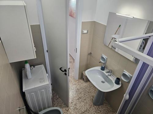 Un baño pequeño con lavabo e inodoro. en The White House, en Torre Suda