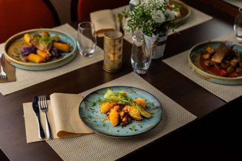 a table with plates of food on a table at Benczur Hotel in Budapest