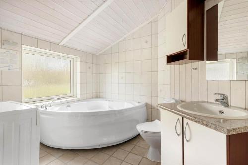 ein Badezimmer mit Badewanne, Waschbecken und Toilette in der Unterkunft 1419 Aakirkeby - Boesparken 16 in Vester Sømarken