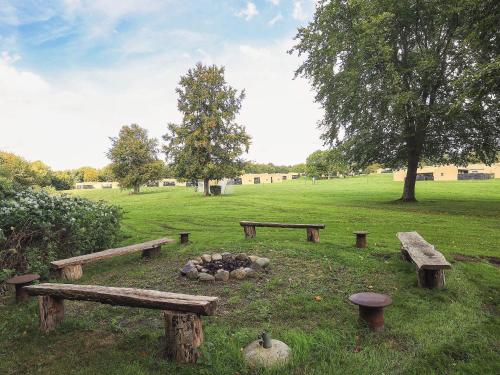 a park with benches and a fire pit in the grass at Middelfart Holiday Center in Middelfart