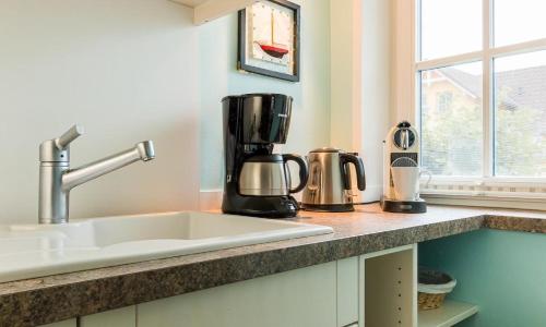a kitchen counter with a sink and a coffee maker at Wellenzauber in Ahrenshoop