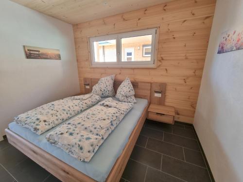 グラーフェンハウゼンにあるMettmapark - Chalet 1の木造キャビン内のベッド1台が備わるベッドルーム1室を利用します。
