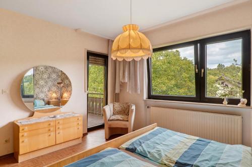 a bedroom with a bed and a mirror and a chair at Ferienwohnung Waidbachhof in Sinsheim