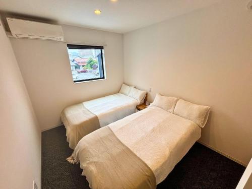 a small room with two beds and a window at Izumo-shuku MAICHI STAY - Vacation STAY 00202v in Izumo