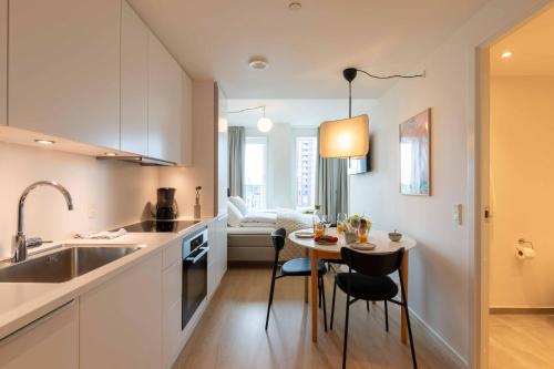 a kitchen with a small table and chairs in a room at Cozy 9th Floor Apartment in Vesterbro in Copenhagen