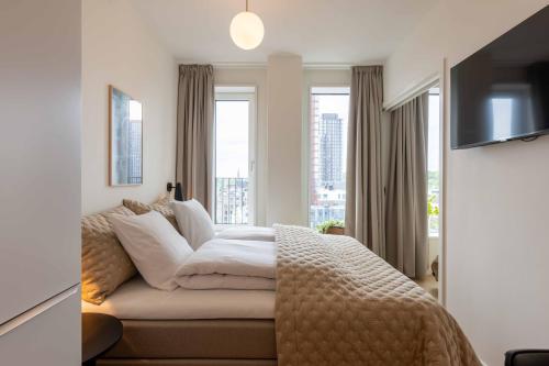 a hotel room with a bed and a television at Cozy 9th Floor Apartment in Vesterbro in Copenhagen