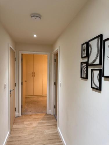 a hallway with white walls and pictures on the wall at New London 2-Bedroom 2-Bath Apartment- Contractors and Long Stays Dis-Count in Colindale